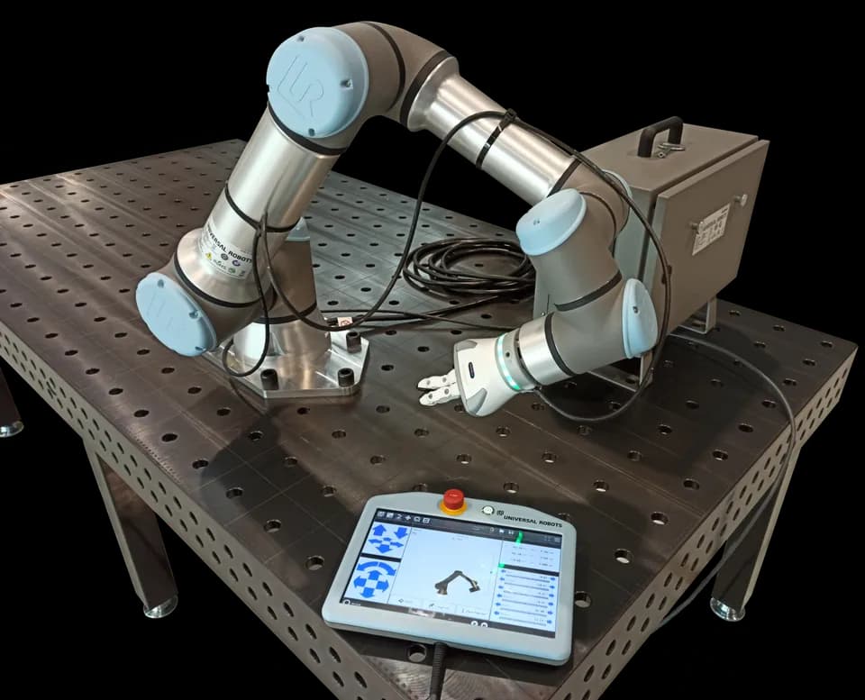 Коллаборативный робот Universal Robots UR16e на перфорированном столе с контроллером и пультом обучения
