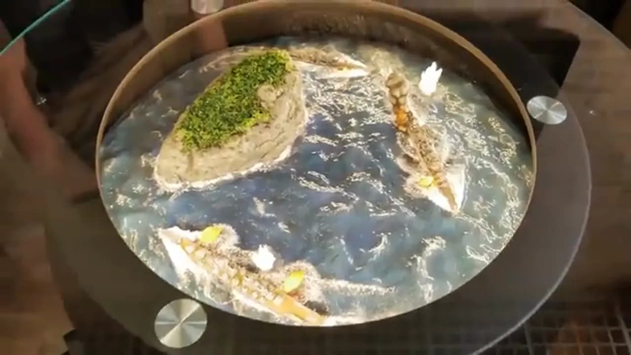 Круглая столешница под стеклом с диорамой кораблей и острова