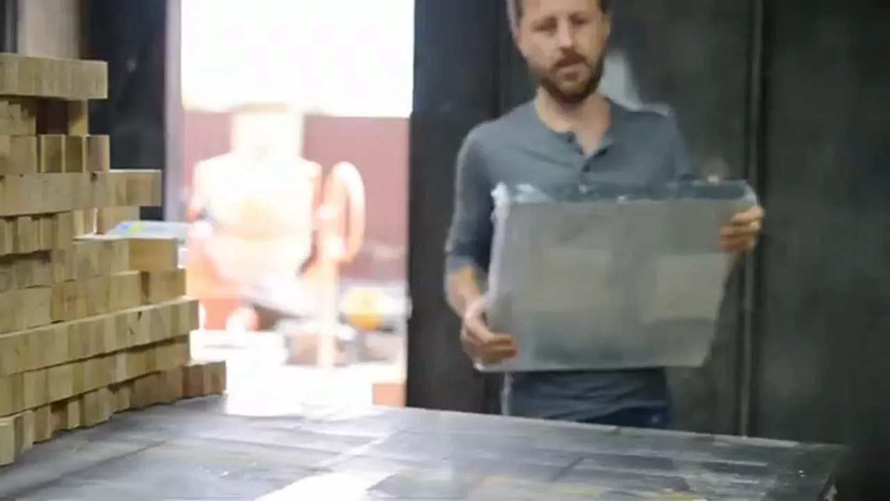 Мужчина держит перед собой лист стекла